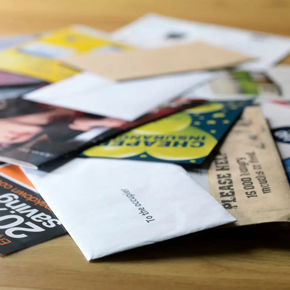 A pile of mail sitting on top of a table.