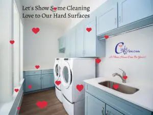 A residential laundry room with washer, dryer, painted cabinets with drawers, a window, wood flooring and a sink.