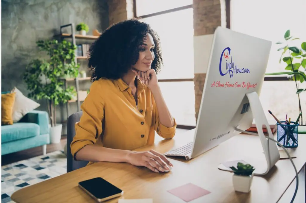 Professionally dressed woman sitting at a desk in front of the computer