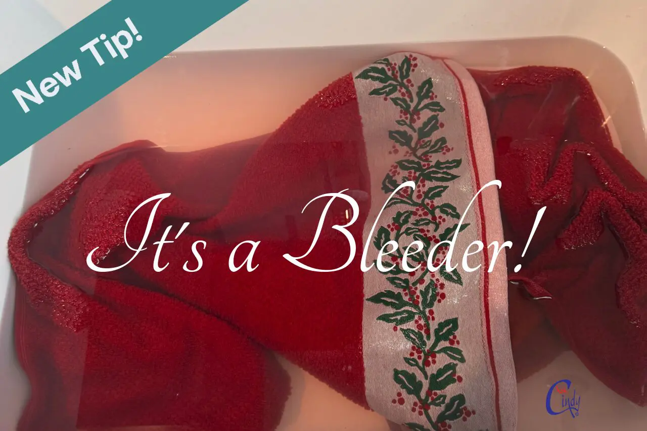 decorative red holiday towel soaking in a basin - the color red is bleeding color during the washing process