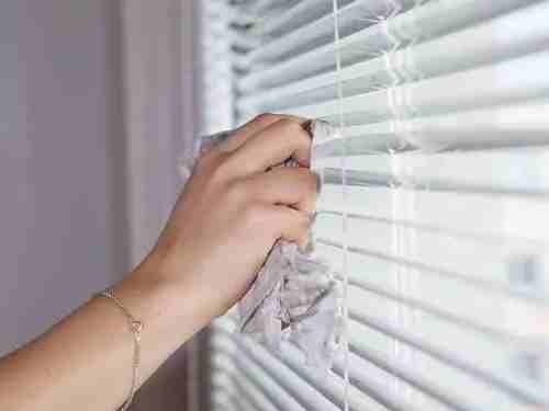 a hand cleaning horizontal blinds