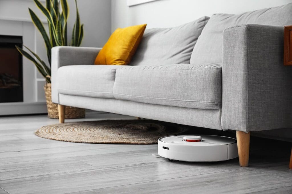 A robotic vacuum cleaning under the couch